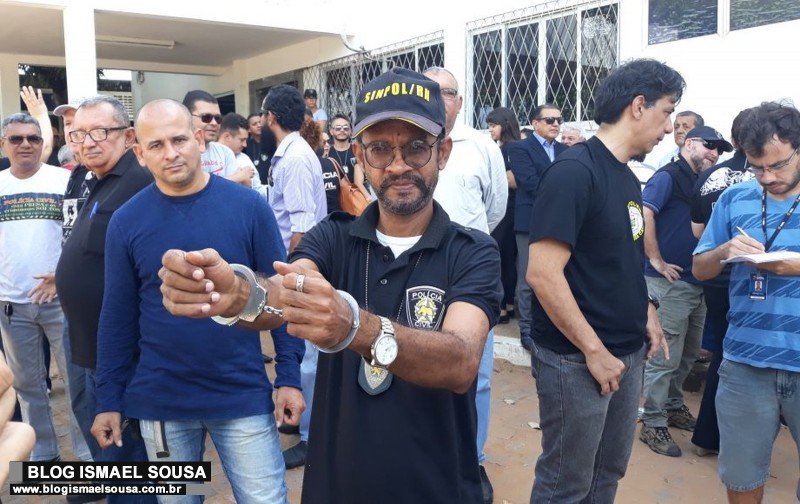 Com algemas nos punhos, policiais civis se apresentam para serem presos
